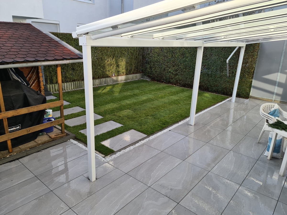 Neue Terrasse aus Feinsteinzeug mit Überdachung und Schrittplatten im Rasen, Stuttgart-Zuffenhausen