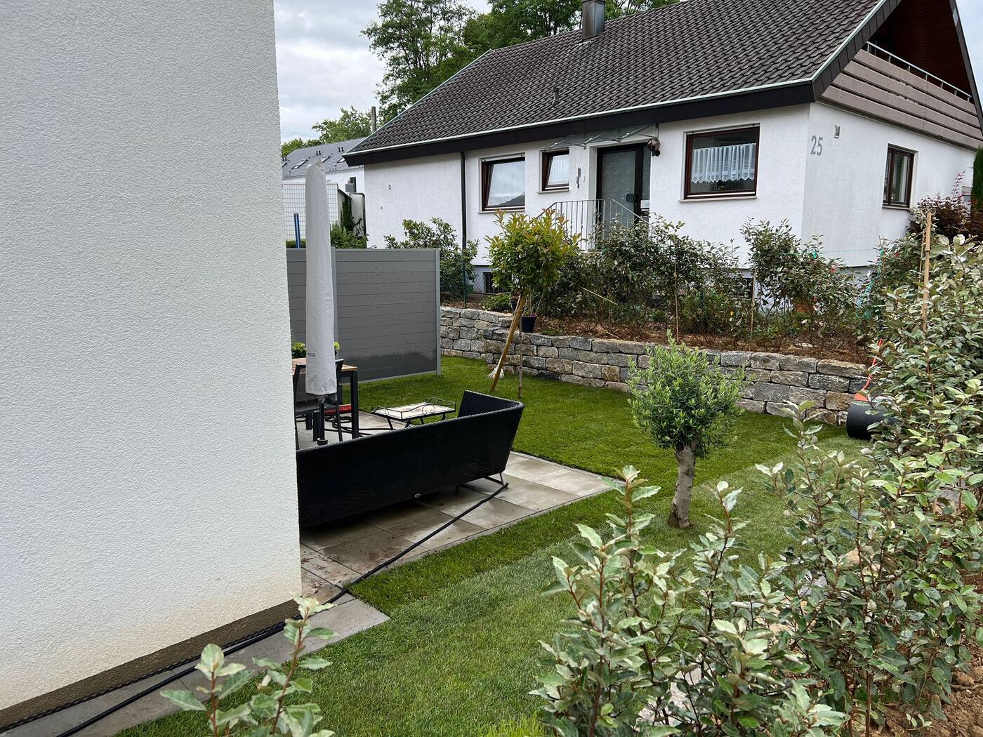 Fertiger Privatgarten mit Rollrasen, Natursteinmauer und Bepflanzung